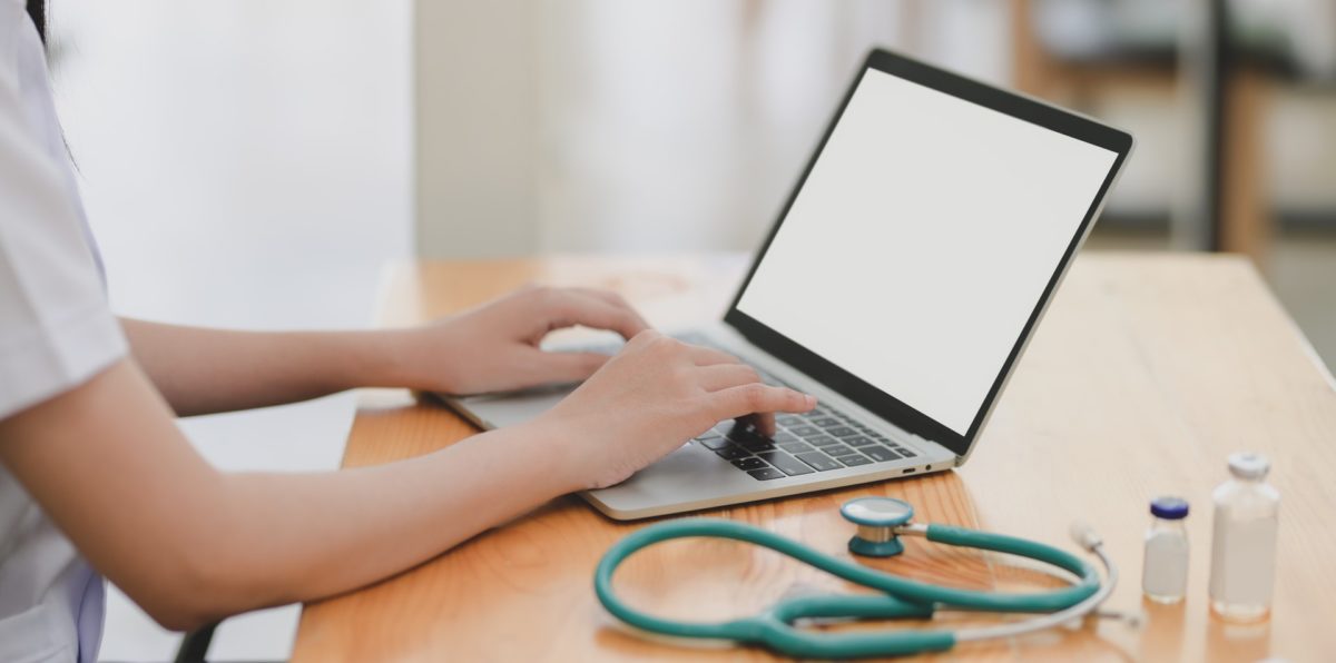 laptop near teal stethoscope in wooden table 3758756