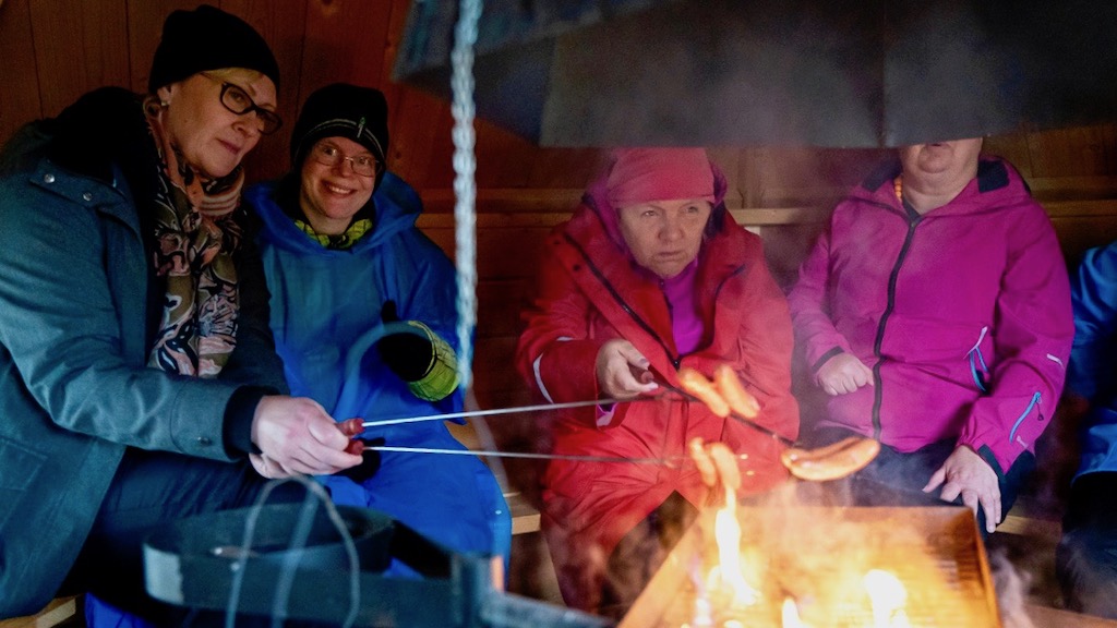 People of Sofiakylä by an open fire